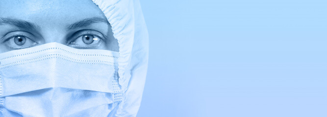 Caucasian doctor or nurse in a special protective suit and mask looking at the camera, copy space