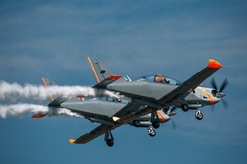 A group of jet airplanes makes smoke trails during an airshow