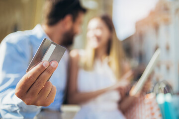 Young couple using a digital tablet for online shopping outdoor.