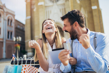Young couple using a digital tablet for online shopping outdoor.