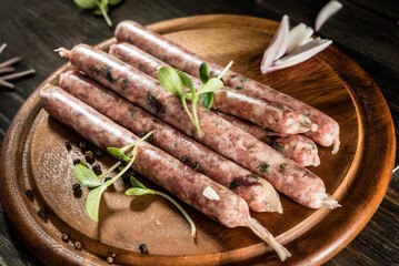 raw sausages on the wooden tray