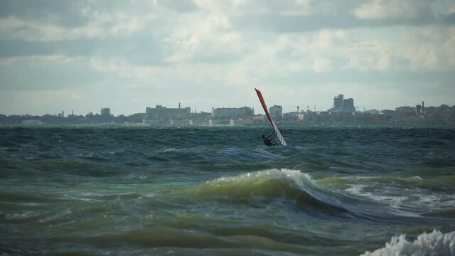 Windsurfer gliding on the emerald ocean, extreme sport. Storm at sea, Evpatoria, Crimea.