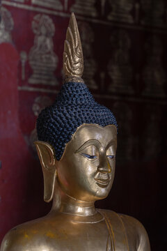 Head of beautiful ancient gilded Buddha statue with flame finial inside heritage Wat Prasat buddhist temple, Chiang Mai, Thailand