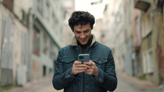 Handsome guy walking on street and using cell phone