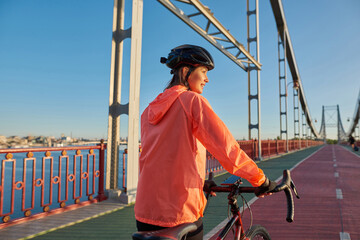 Happy 20s Caucasian female cyclist train bike outdoors