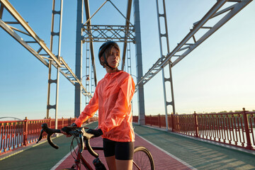 Millennial female cyclist in sportswear bike outdoors