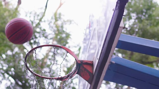 the basketball is spinning on the hoop and misses.Slow motion
