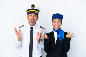 Airplane pilot and mixed race air hostess isolated on white background with surprise and shocked...