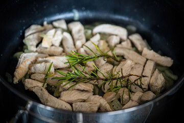  roasted turkey chopped meat in a hot pan with rosemary