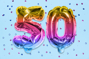 Rainbow foil balloon number, digit fifty on a blue background with sequins. Birthday greeting card...