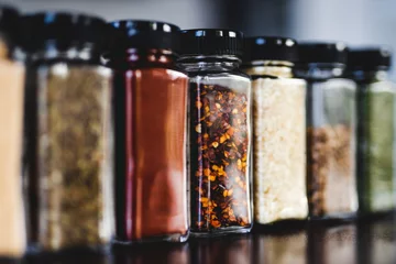 Schilderijen op glas spices seeds and seasonings in mathing spice jars on tidy pantry shelf, simple vegan ingredients and flavoring your dishes © faithie