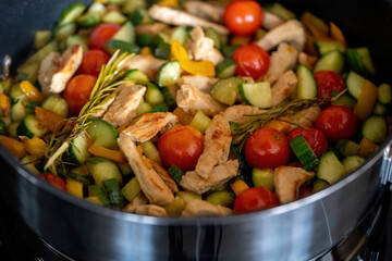 roasted chopped turkey with cherry tomatoes, cucumber, yellow paprika in a hot pan