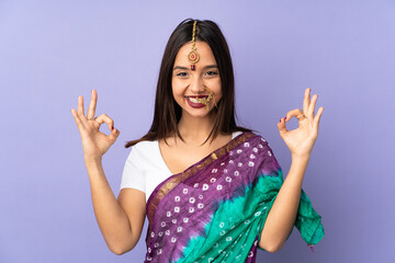 Young Indian woman isolated on purple background in zen pose