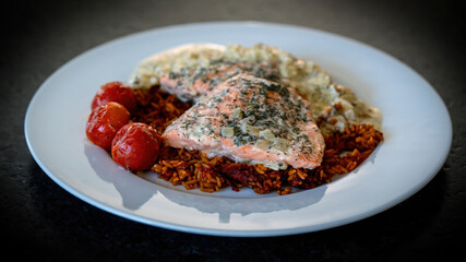 healthy and ready to eat - grilled salmon fillet with rice in onion creme sauce and cherry tomatoes