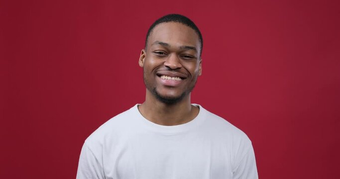 Happy african american man inviting to come over maroon background