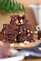 A stack of chocolate brownies with peanuts on snack table. Homemade bakery and dessert.