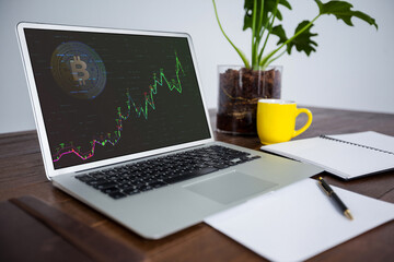 Laptop on desk with statistical and financial data on screen