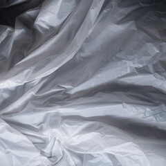 Fototapeta premium Reflecting light and shadow on creases and folds in scrunched white fabric or plastic sheet