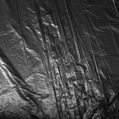 Reflected light and shadow on creases and folds in black plastic sheeting