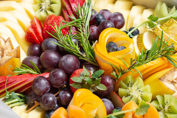 Red grapes, orange, pineapple pieces and other fruits close-up