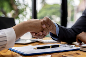 Two businesswomen shake hands after accepting a business proposal together, a handshake is a universal homage, often used in greeting or congratulations.