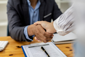 Two businesswomen shake hands after accepting a business proposal together, a handshake is a universal homage, often used in greeting or congratulations.