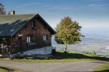 Fototapeta na wymiar Haus in den Bergen bei blauen Himmel und Sonnenschein. Allgäuer Ausblick.