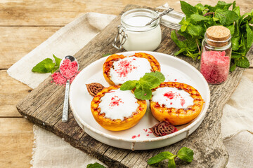 Grilled peach with yogurt, mint, and sweet pink sugar. Useful breakfast concept, healthy food