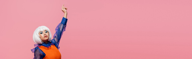 Pretty asian pop art woman in white wig looking at camera isolated on pink, banner