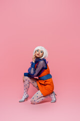 Stylish asian pop art woman looking at camera on pink background