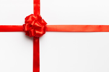 Top view of Red ribbon rolled and red bow isolated on colored background. Flat lay with copy space