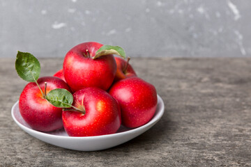 juicy red apples in a bowl or plate on the table top view. Copy space