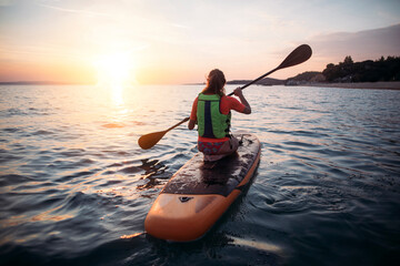 Rear view of woman paddleboarding 
