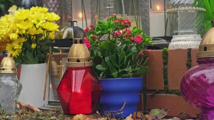 Flowers and Glass Memorial Lantern Candles and Cemetery Columbarium Funeral Urn Wall Before All Saints Day	