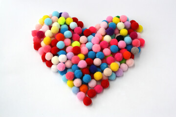 Fluffy pom-poms are in the shape of a heart.