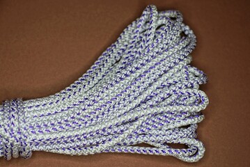 one skein of white rope lies on a brown table