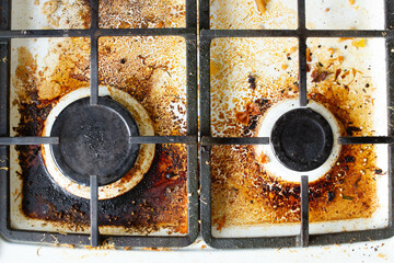 Dirty gas stove surface. Two gas burners and cast iron grate of a gas oven surrounded by old...