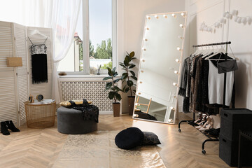 Stylish dressing room interior with trendy clothes and shoes