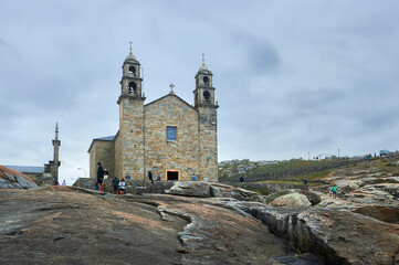 Fototapeta na wymiar sanctuary of our lady of the boat with visitors seen from the rocks of the coast