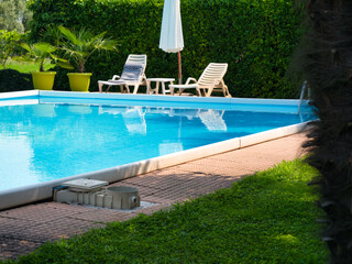 outdoor summer pool with blue water in the garden
