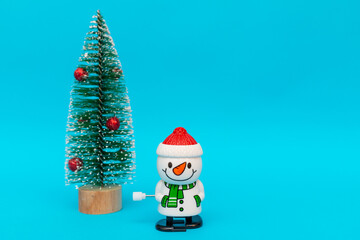 Toy snowman christmas tree on blue background copy space. Merry Christmas and Happy New Year.
