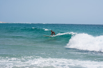 Woman seen riding wave with her surfboard