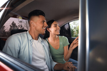 Happy couple on backseat of modern taxi