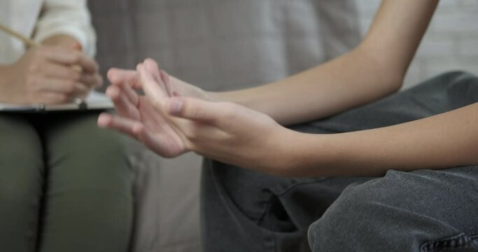 Therapist help in quarantine. A woman therapist speak with child and write her problems in the notebook.