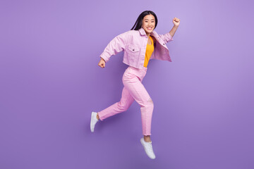 Fototapeta na wymiar Full size profile photo of funky millennial brunette lady run wear jacket jeans sneakers isolated on violet background