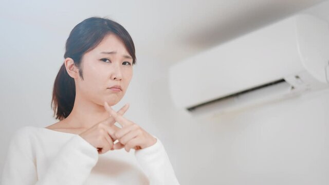 バッテンをする女性　エアコンイメージ