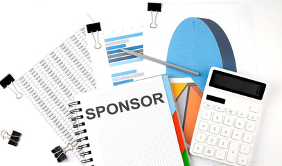Text SPONSOR on a notebook on the diagram and charts with calculator and pen