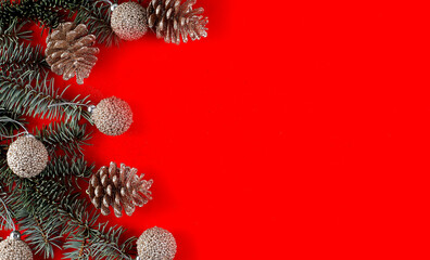 Christmas red decorations, fir tree branches and balls on red background. copy space