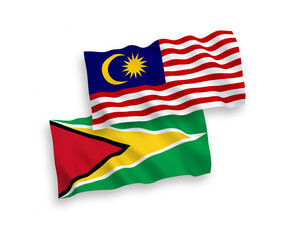 National vector fabric wave flags of Co-operative Republic of Guyana and Malaysia isolated on white background. 1 to 2 proportion.