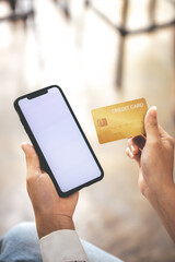 female hand holding phone and credit card
